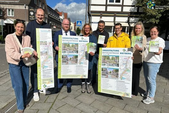 Teilnehmende Händler und Gastronomen mit Plakaten und Werbematerial.